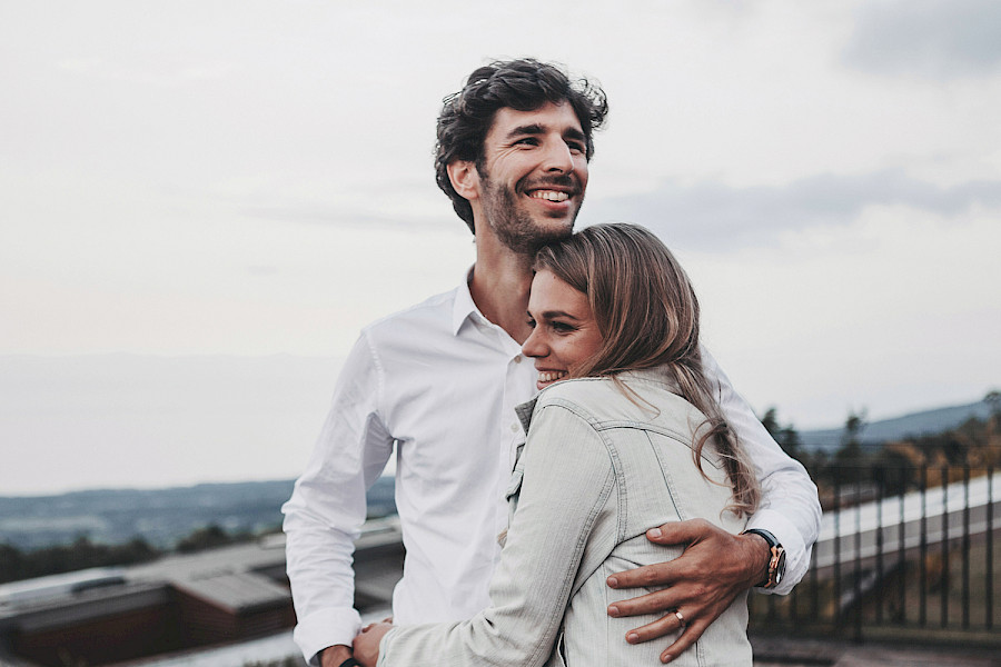 Hallin Löfgren Juristbyrå AB - A young couple embracing on a terrace overlooking the sea.