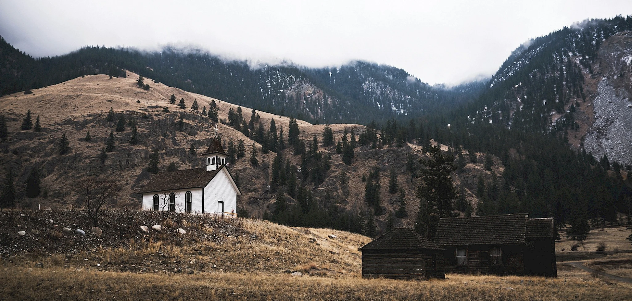 Hallin Löfgren Juristbyrå - An old church in the mountains with a majestic mountain in the background.