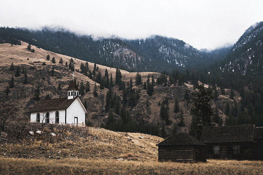 Hallin Löfgren Juristbyrå - An old church in the mountains with a majestic mountain in the background.